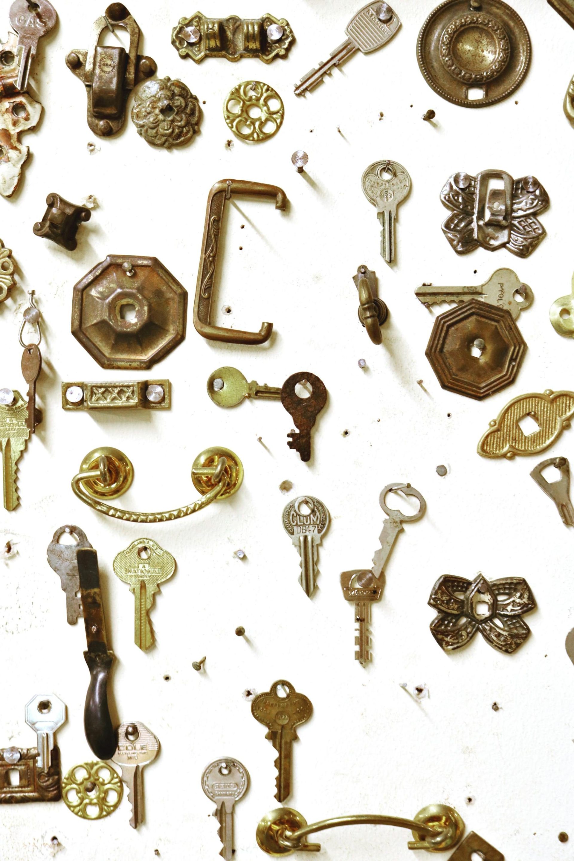 Assorted vintage keys and hardware showcased on a white background, highlighting intricate designs.