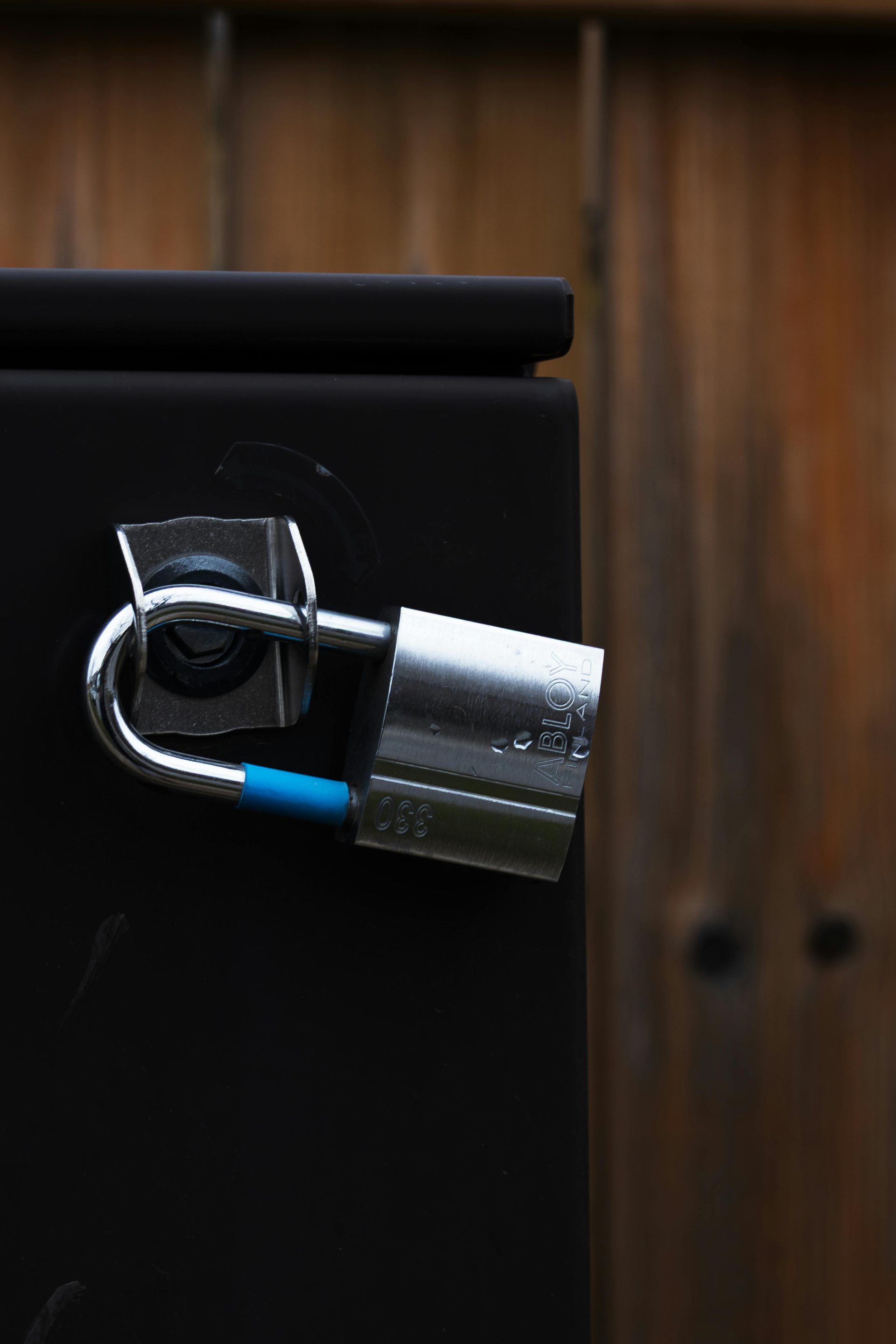 A detailed view of a shiny metal padlock securing a door, symbolizing security and protection.